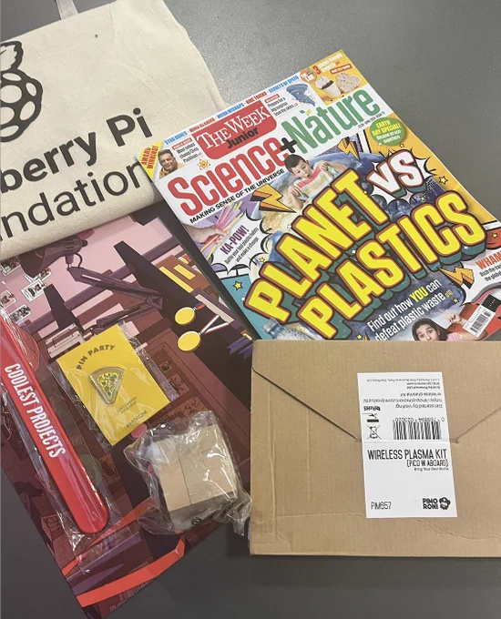 The Coolest Projects goodie bag including a Science   Nature magazine, a pin badge, a digital projects and a red USB bracelet.