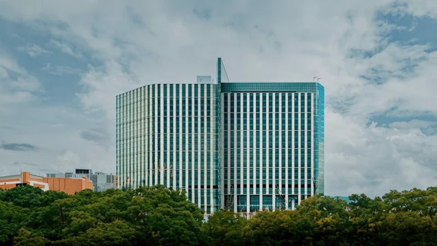Inpatient Tower with clouds behind and trees in front.