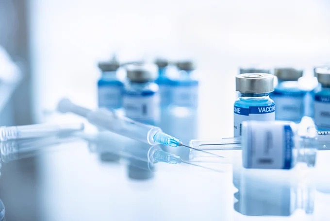 Vaccines and syringes on a table.