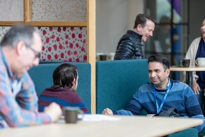 Two male technicians sat chatting at conference