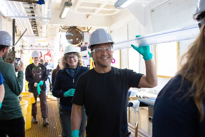 Tomoaki Morishita (Igneous Petrologist, Kanazawa University, Japan), front, and Paola Vannucchi (Structural Geologist/Petrologist, University of Florence, Italy), behind, hold a core liner on the catwalk. (Credit: Kristin Bronk, IODP JRSO)