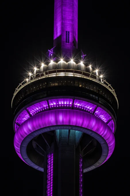 Closeup of the CN Tower at night, lit in purple / Gros plan de la Tour CN de nuit, éclairée en violet