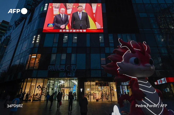 A large screen shows news coverage of Chinese President Xi Jinping (R) meeting German Chancellor Olaf Scholz in Beijing on April 16, 2024.