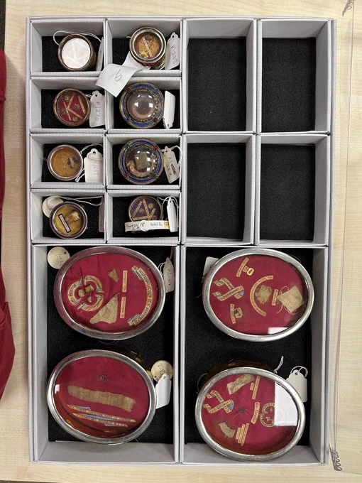 Photo of an archive box holding many small reliquaries