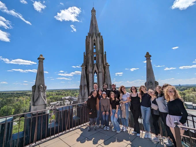 group of people standing together on landing at top of Duke Chapel with view of campus behind them