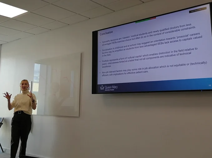 Dr Louise Ashley standing in front of her Conclusion slide during the seminar. 