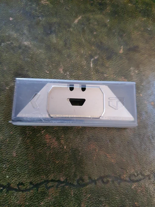 Metal knife.plades in a plastic packet, with holes that look like a smiley face