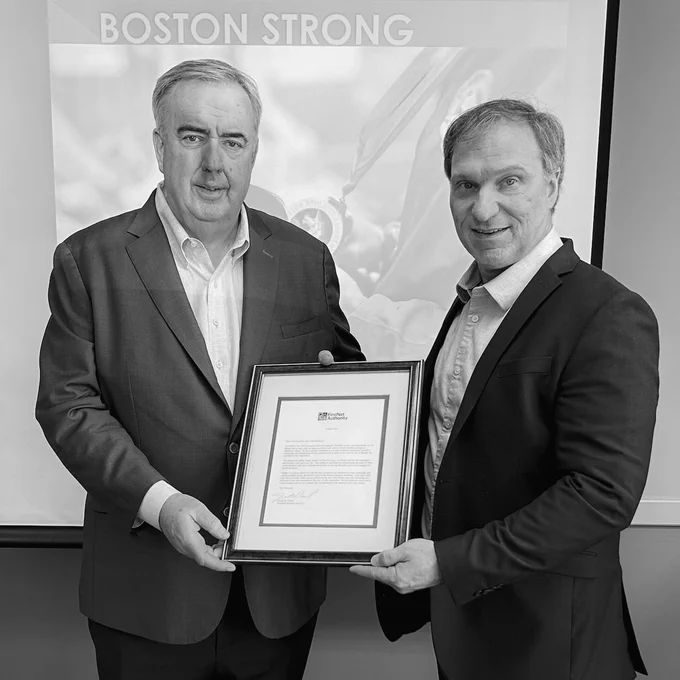 Former Boston Police Commissioner Ed Davis holds a letter with FirstNet Authority Executive Director and CEO Joe Wassel after presenting on his experiences during the Boston Marathon bombing.