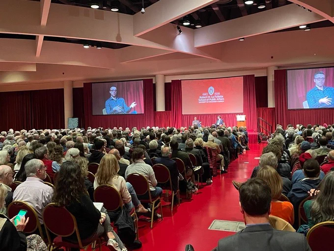 Ezra Klein sits on a stage presenting to an audience.