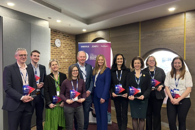 A group of people standing together holding awards.