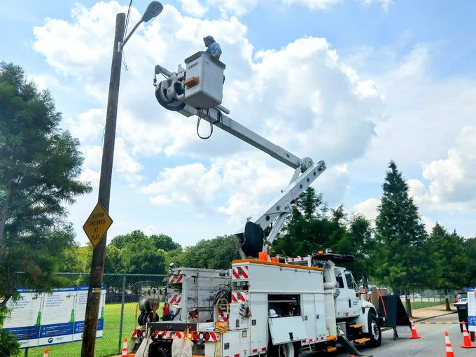 A worker in a cherry picker truck