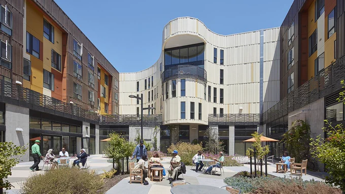Flexible, biophilic courtyard shared by George W. Davis Senior Housing residents and the attached neighborhood-serving community center, framed by Afrocentric design elements. (Bruce Damonte)