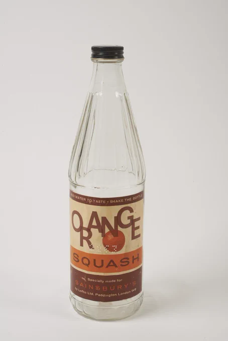 Bottle for Sainsbury's Orange Squash, made for Sainsbury's by Lofko Ltd, Paddington, London, W9.

Glass bottle with screw top lid used to contain orange cordial drink. Paper label features name of product, preparation instruction and picture of an orange. Black screw top lid bears the price 1/9. A number '2263' is perforated into the label'.