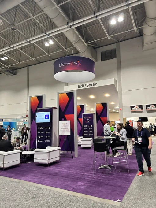 Image of the OCI DisocveryX welcome centre, with purple rug and red and orange gradient shapes in background, modern white furniture.