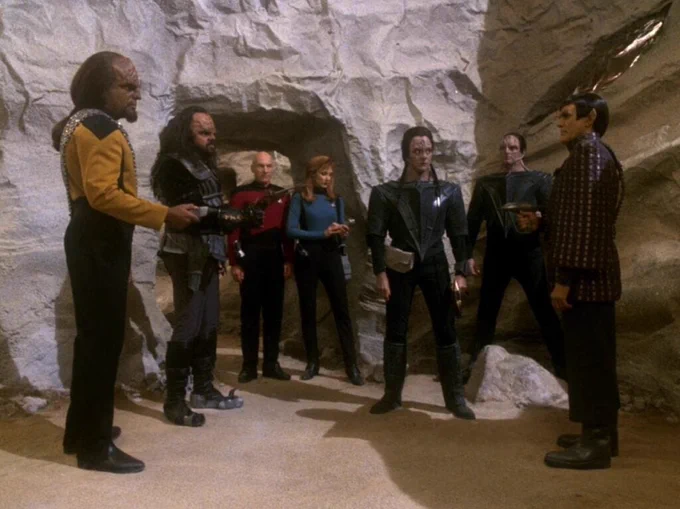Picard and Beverly see a window of opportunity as Worf and a Klingon, two Cardassians and a Romulan argue.