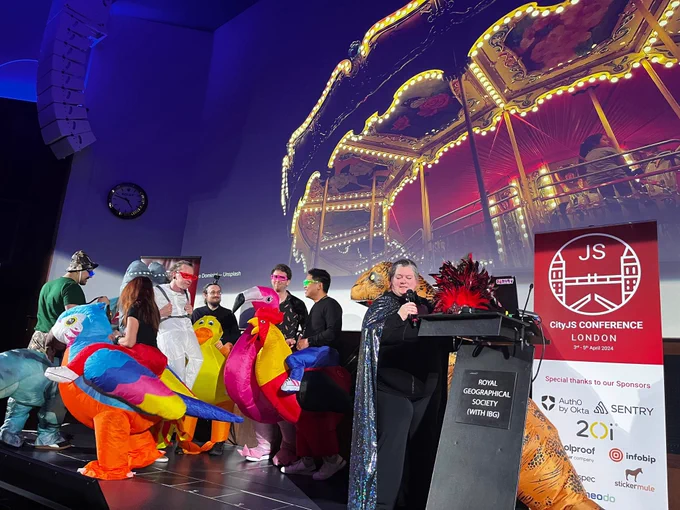 Carnival onstage of costumes speakers wearing inflatable animals next to me as I present