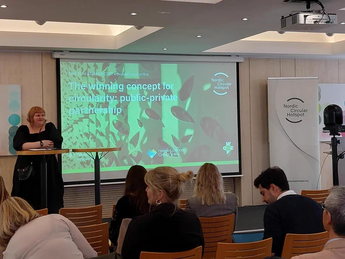 Presenter on the stage. On the Powerpoint slide there is text: The winning concept for circularity: public-private partnership.