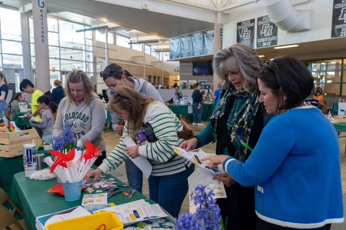 Five people look at information at a table during the Mental Health Matters resource fair.
