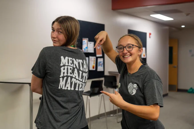 Two students pose for a photo at the 2024 Mental Health Matters event. Both are wearing shirts that say Mental Health Matters.