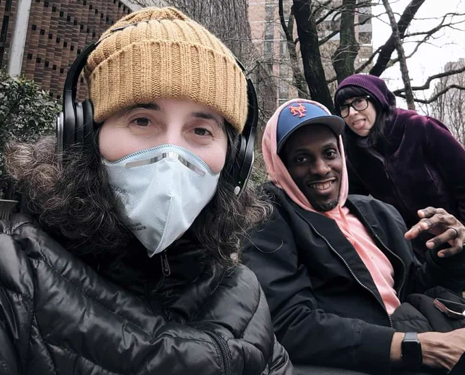 A white passing woman in a Respokare N95 mask poses with a Black man and a Latinx female presenting person