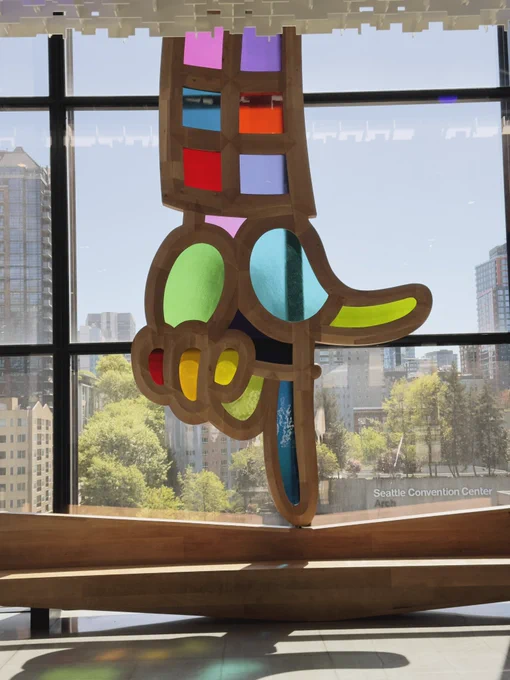 Art work with multi-colored stained glads hand pointing down