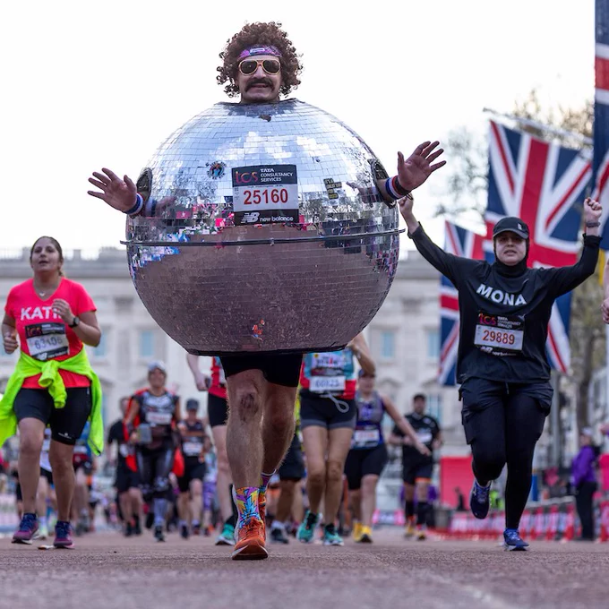 Ricky Passam, wearing fancy dress, celebrates as they run down The Mall towards the finish line during The TCS London Marathon on Sunday 23rd April 2023.