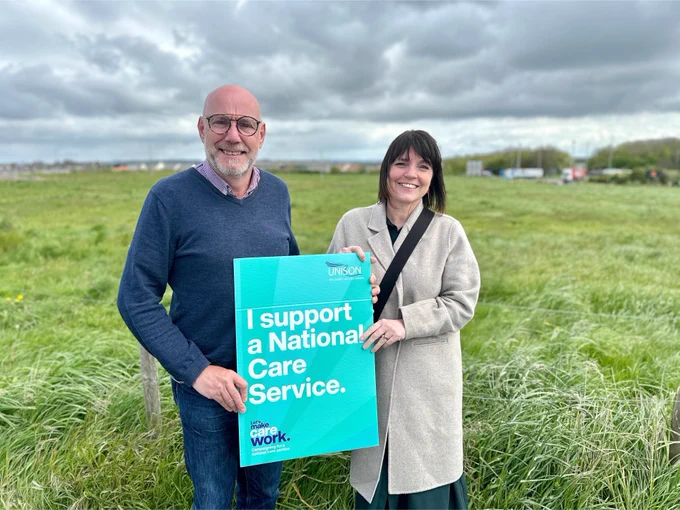 Leigh Redman and Kerry Baigent hold the pledge board which reads 'I support a national care service'. 