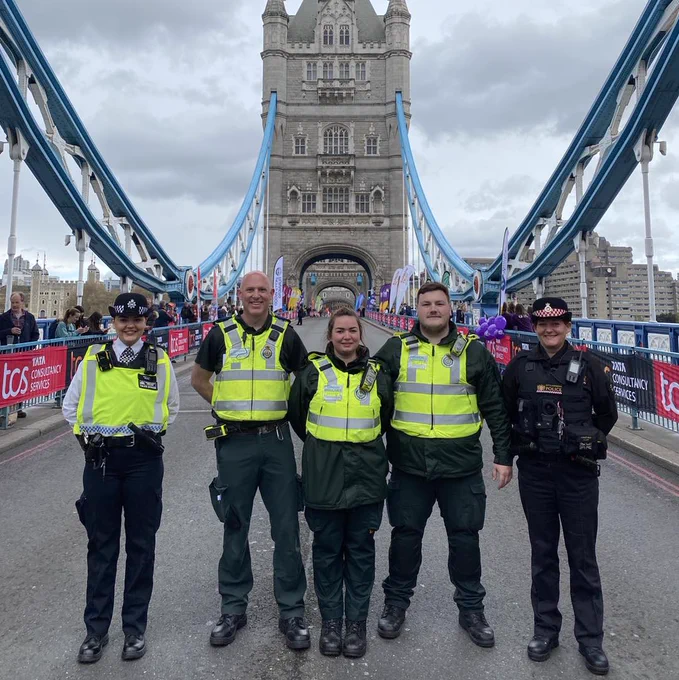 Image shows London Ambulance staff with policing staff, standing on London Bridge before the 2023 London Marathon starts. 