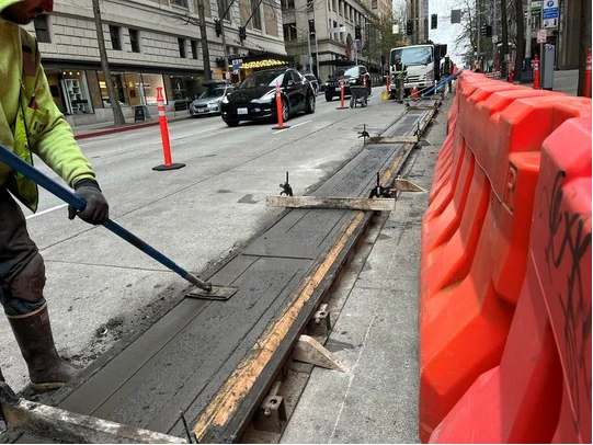 Curbs are finished by hand by a crew member.