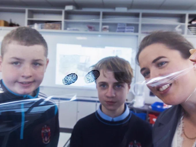 2 students and Róisín pictured with their finger prints on an acetate sheet