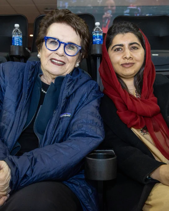 Billie Jean King and Malala Yousafzai smiling for a photo at a PWHL New York game. 