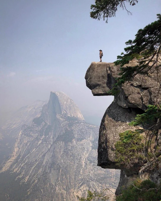 outstanding landscape photo of man standing on the cliff in Yosemite shot on iPhone