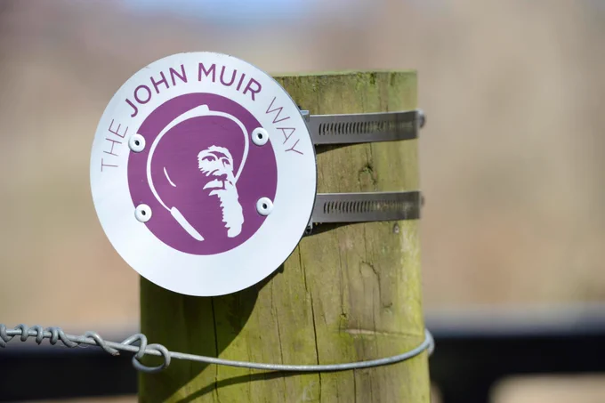 Close up photo of a John Muir Way sign on a fence post. Image credit: Lorne Gill/NatureScot