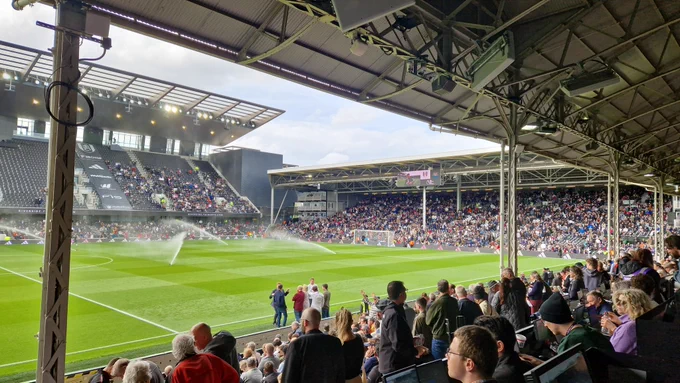 Photo of the Craven cottage pitch at half-time, with the sprinklers on the pitch 