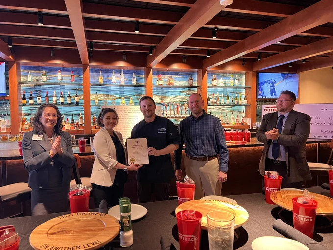 Council Vice President Stewart presenting proprietor Michael Wise a certificate for the opening at Outback in downtown Silver Spring.