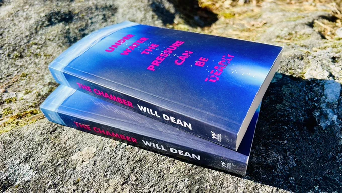 The Chamber (ARC copy - pink text ‘Under water the pressure can be deadly’, blue undersea background) Rock backdrop. 2 copies.