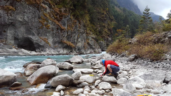 A researcher crouches on the rocky bank of a glacial river, collecting water to study. The water is pale blue. Cliffs and tall trees are across the other side of the river. Read more about our colleagues' glacier research: https://environment.leeds.ac.uk/faculty/news/article/5676/from-running-rivers-to-retreating-glaciers-supporting-world-water-week-at-leeds