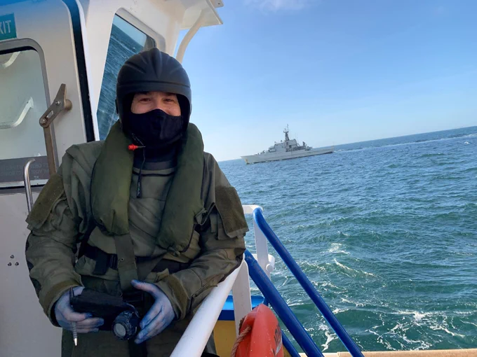 Sailor on the bridge wing of an offshore patrol vessel at sea
