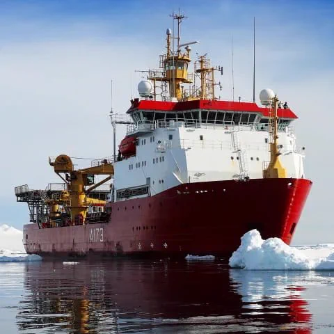 HMS Protector distinguishable by its red paint, on patrol in the Antarctic.