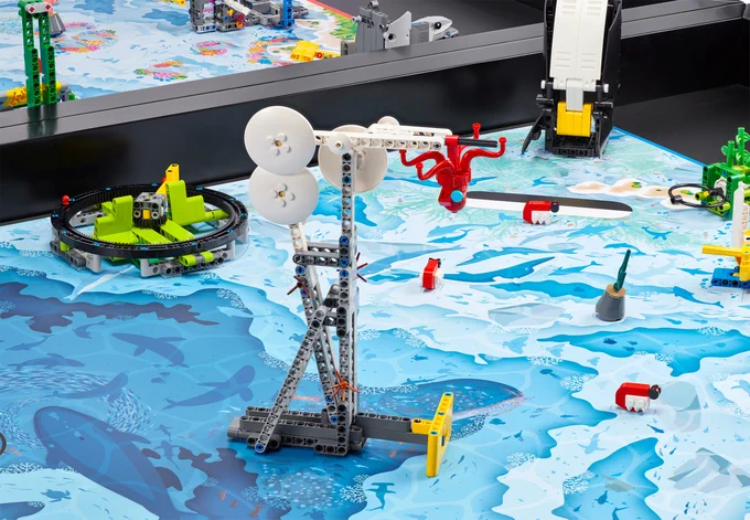 robotics competition board with blue underwater theme; LEGO builds on top