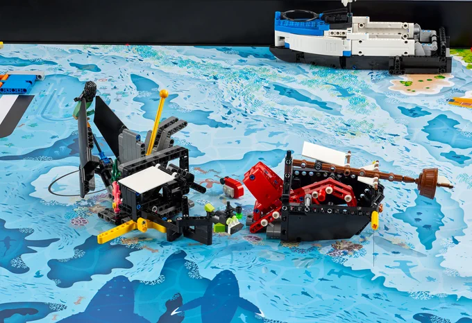 robotics competition board with blue underwater theme; LEGO builds on top
