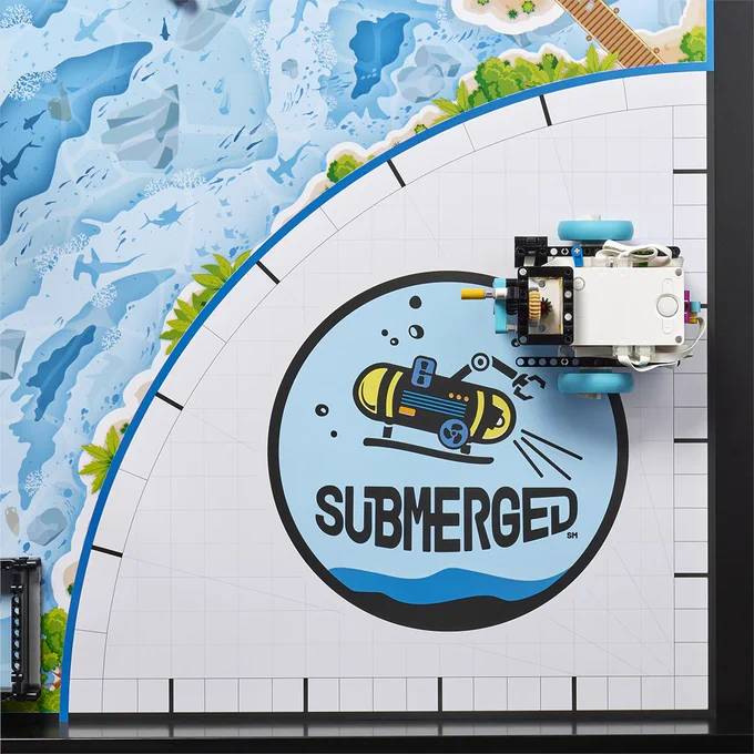robotics competition board with blue underwater theme; LEGO Education SPIKE Prime build on top near SUBMERGED logo