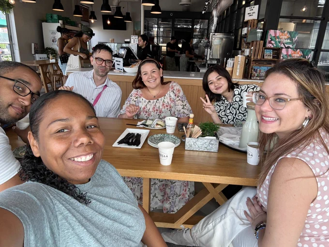 Selfie of six people in a cafe