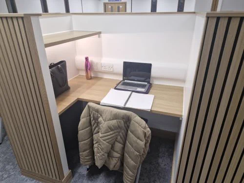 Image of a study space with open laptop and notepad on the desk at University of Dundee Library