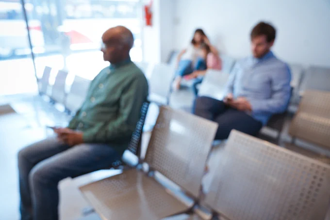 Out of focus image of three patients in hospital waiting room