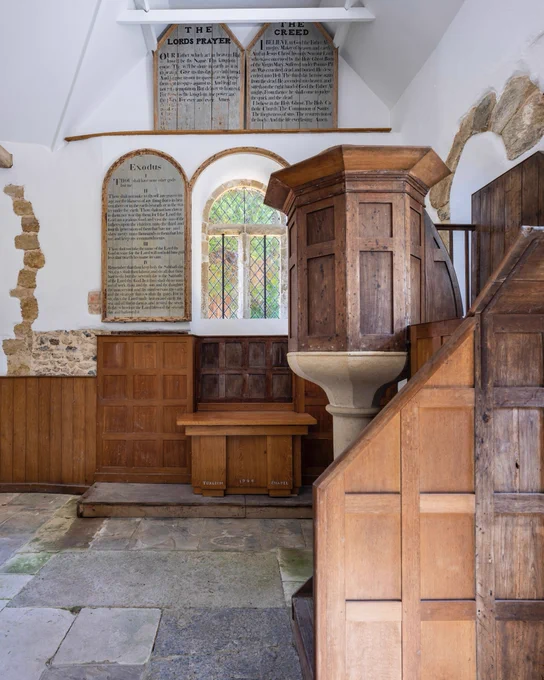 The wood panelled and white washed interior of the chapel. The Georgian pulpit and decalogue boards can be seen.
