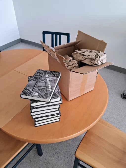 Photo of multiple copies of the book described in the previous image.