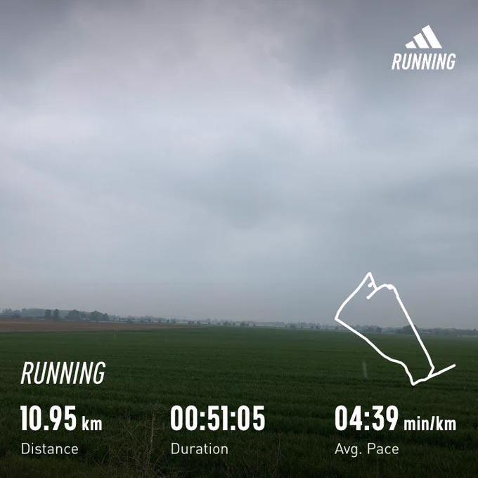 Cloudy sky over a green field; running stats superimposed (10.95km in 51:05)