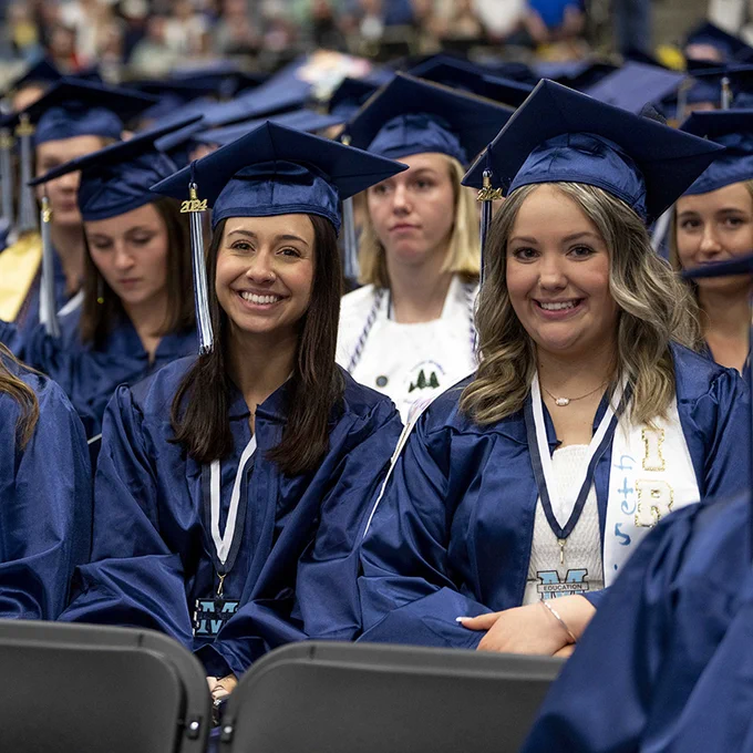 University of Maine College of Education and Human Development students smiling at the 2024 commencement ceremony.