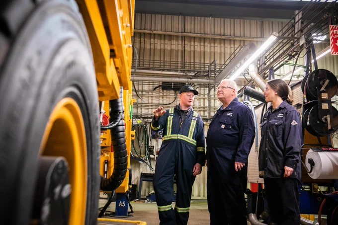 Premier Doug Ford and two employees look at a machine in the Maclean Engineering facility.